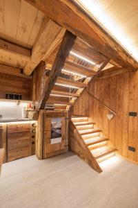 - un escalier dans une cuisine avec des murs et des plafonds en bois dans l'établissement Casa Vacanze I Foresti C'A D'Arte, à San Damiano Macra