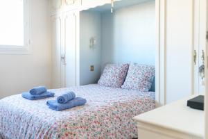 a bedroom with a bed with blue towels on it at Appartement spacieux idéalement situé sur le remblai des Sables dOlonne in Les Sables-dʼOlonne