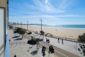 a view of a beach with people and the ocean at Appartement spacieux idéalement situé sur le remblai des Sables dOlonne in Les Sables-dʼOlonne