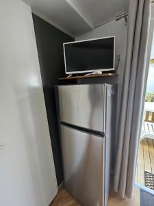 a silver refrigerator with a tv on top of it at Mobil home 3 chambres (413) in Saint-Jean-de-Monts