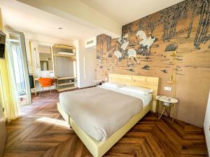 a bedroom with a large bed and a mural on the wall at Hotel Vittorio in Desenzano del Garda