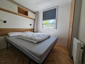 a bed in a bedroom with a window at Mobil home 3 chambres (413) in Saint-Jean-de-Monts