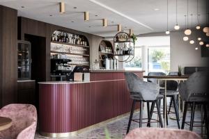 a bar in a restaurant with tables and chairs at Hotel Erzherzog Johann in Schenna