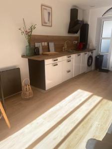 a kitchen with white cabinets and a counter top at GE Appart Lille Douai Valenciennes à 20 min et à 3 mn orchies gare Lille Orchies parking terrasse in Coutiches +5 photos