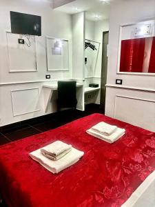 a bathroom with a red bed with towels on it at Palace Rome in Rome