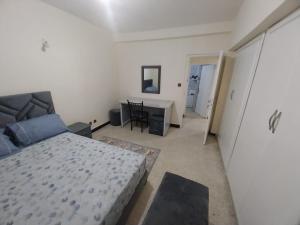 1 dormitorio con cama y escritorio. en Superbe appartement à louer,Hassan en Rabat