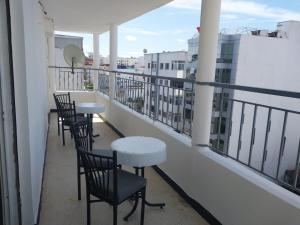 une rangée de chaises et de tables sur un balcon dans l'établissement Superbe appartement à louer,Hassan, à Rabat