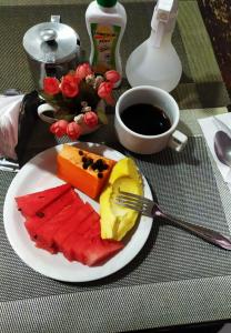 a plate of fruit with a fork on a table at Hotel Rio Branco in Jequié