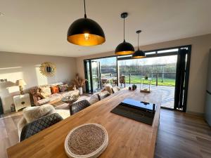 a living room with a large wooden table and chairs at Zen Jungle Retreat - Log Cabin Stays, Transformational Retreats & Holistic Wellness near Bude - A 40 Acre Retreat with 5 Lakes, Woodland, Firepits, Bistro & Bars in Holsworthy