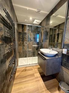 a bathroom with a sink and a shower at Zen Jungle Retreat - Log Cabin Stays, Transformational Retreats & Holistic Wellness near Bude - A 40 Acre Retreat with 5 Lakes, Woodland, Firepits, Bistro & Bars in Holsworthy