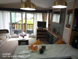 ein Wohnzimmer mit einem Tisch und einem Teller mit Lebensmitteln in der Unterkunft Stag Lodge in Great Yarmouth