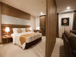 a hotel room with a bed and a couch at Garden Sentral Hotel in Kuala Belait