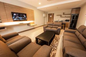 a large living room with couches and a tv at Garden Sentral Hotel in Kuala Belait