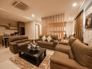 a living room with two couches and a table at Garden Sentral Hotel in Kuala Belait