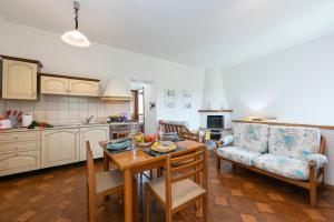 eine Küche und ein Wohnzimmer mit einem Tisch und einem Sofa in der Unterkunft Charming La Gelosia Few Min From Lake in  Monvalle 