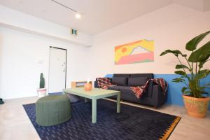 sala de estar con sofá y mesa en Breaky Hotel 中長期滞在向けのラグジュアリーモーテル空間 無料駐車場有, en Chatan