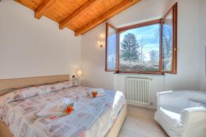 um quarto com uma cama, uma janela e uma cadeira em La Brezza Del Lago Maggiore with view - Happy Rentals em Laveno-Mombello