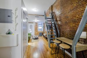 a room with a brick wall and a staircase at Experience the Vibrant Energy of City Living in New York