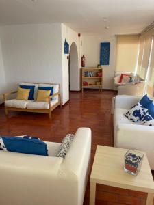 een woonkamer met twee witte banken en een tafel bij Dona Ana Pensão Residencial in Lagos