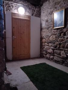 Habitación con puerta de madera en una pared de piedra. en Studio cosy duplex dans château médiéval, en Le Poujol-sur-Orb