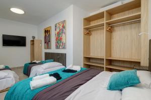 une chambre avec deux lits et une télévision à écran plat dans l'établissement Penthouse Apartment Tribuna Center By Seric,15' walking to the beach, à Malaga