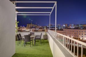 un balcon avec une table et des chaises et un horizon de la ville dans l'établissement Penthouse Apartment Tribuna Center By Seric,15' walking to the beach, à Malaga