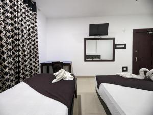 a hotel room with two beds and a mirror at Big John Hotel in Dehiwala
