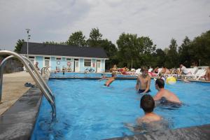 a group of people playing in a swimming pool at Holiday Resort & Camping InterCamp'84 in Łeba