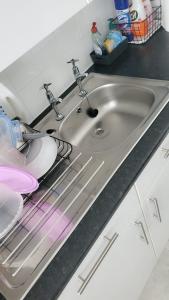a stainless steel sink in a kitchen at Cosy 2 Bedroom Apartment in South West London in London