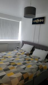 a bedroom with a bed with a checkered floor at Cosy 2 Bedroom Apartment in South West London in London