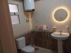 a bathroom with a toilet and a sink and a mirror at كمبوند سيتي تاورز مدينة نصر حي الواحه in Cairo +18 photos
