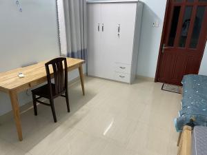 a dining room with a wooden table and a chair at Nhà Nghỉ 846-B44 in Vung Tau