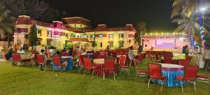 JVS BEAUTY GREEN RESORT في Venkatāpur: مجموعة طاولات وكراسي أمام المبنى