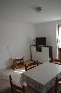 a living room with a table and a television at Apartman Seka in Senj