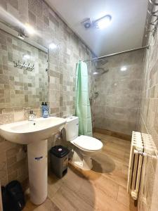 La salle de bains est pourvue d'un lavabo, de toilettes et d'une douche. dans l'établissement AUBERGE JOMANA PARK, à Azrou