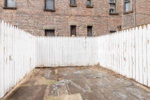a white fence in front of a brick building at Experience the Vibrant Energy of City Living in New York