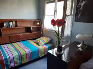 ein Schlafzimmer mit einem Bett und einer Blume auf einem Tisch in der Unterkunft le petit chemin in Bougival