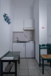 cocina con mesa, fregadero y encimera en Soula Rooms Tinos, en Tinos