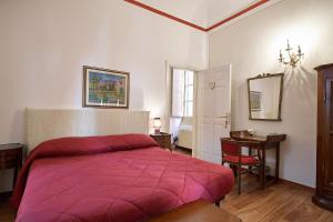 um quarto com uma cama vermelha e uma mesa em Affittacamere San Teodoro em Albenga