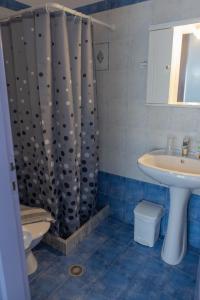 uma casa de banho com uma cortina de chuveiro e um lavatório em Soula Rooms Tinos em Tinos Town
