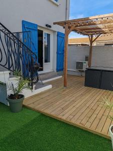 une terrasse en bois avec pergola sur une maison dans l'établissement Superbe appartement pour deux avec jacuzzi, à Vias