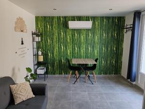 - un salon avec une table et un mur vert dans l'établissement Superbe appartement pour deux avec jacuzzi, à Vias