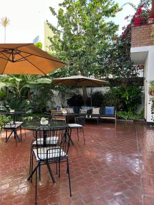 un patio extérieur avec des tables, des chaises et des parasols dans l'établissement Lima 18 Boutique, à Lima