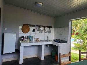 a kitchen with a counter with pots and pans at Bungalow 5 avec piscine à proximité de la plage in Nosy Be
