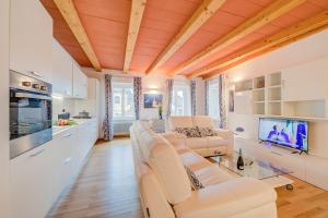 ein Wohnzimmer mit weißen Möbeln und einem TV in der Unterkunft Concordia Apartment Laveno - Happy Rentals in Laveno