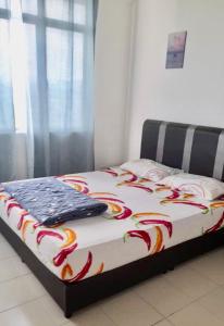 a bed with a colorful blanket on top of it at EZ Apartment in Ipoh