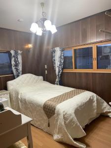 1 dormitorio con cama y lámpara de araña en Rental villa Saya - Vacation STAY 85439v, en Chigasaki