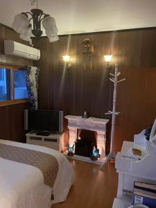 a bedroom with a bed and a fireplace and a tv at Rental villa Saya - Vacation STAY 85439v in Chigasaki