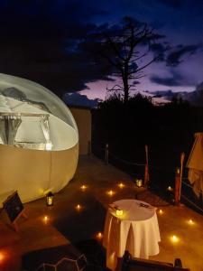 Tienda redonda con mesa y árbol por la noche en The Bubble Valley clarens, en Clarens