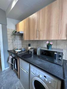 a kitchen with a microwave and a dishwasher in it at Light Budget Studio Apartment on Edgware Road, Central London in London